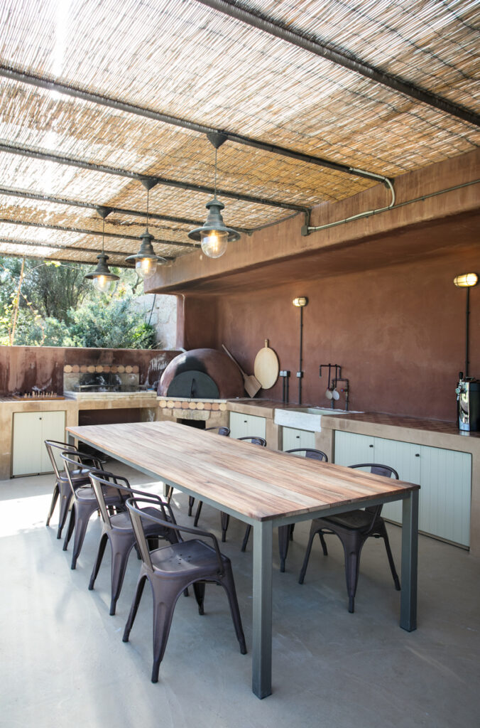 Shaded outdoor dining table under a reed roof